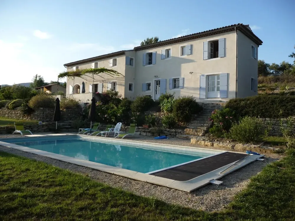 Grande maison à étage aux volets lavande, escalier de pierre et jardin en terrasses au-dessus d’une piscine
